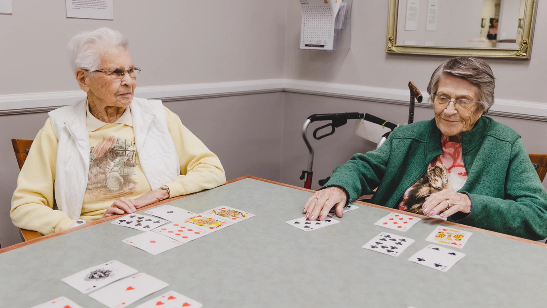Two senior women playing cards in a retirement home