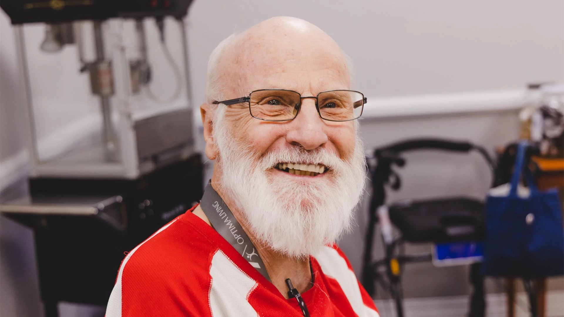 Man with glasses smiling in a retirement home