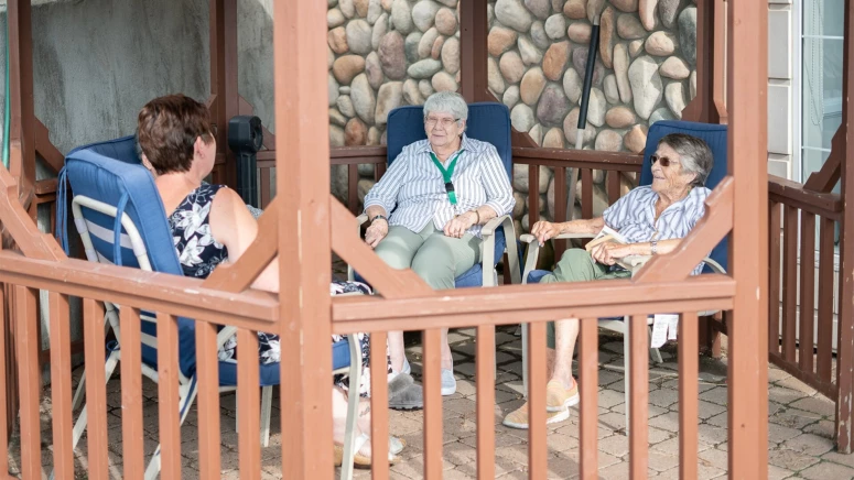 A group of elderly people sitting together under patio at The Hamlets(deer park)