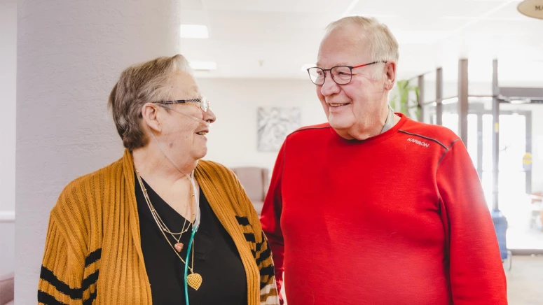 Senior Man and Woman smiling at each other inside senior living