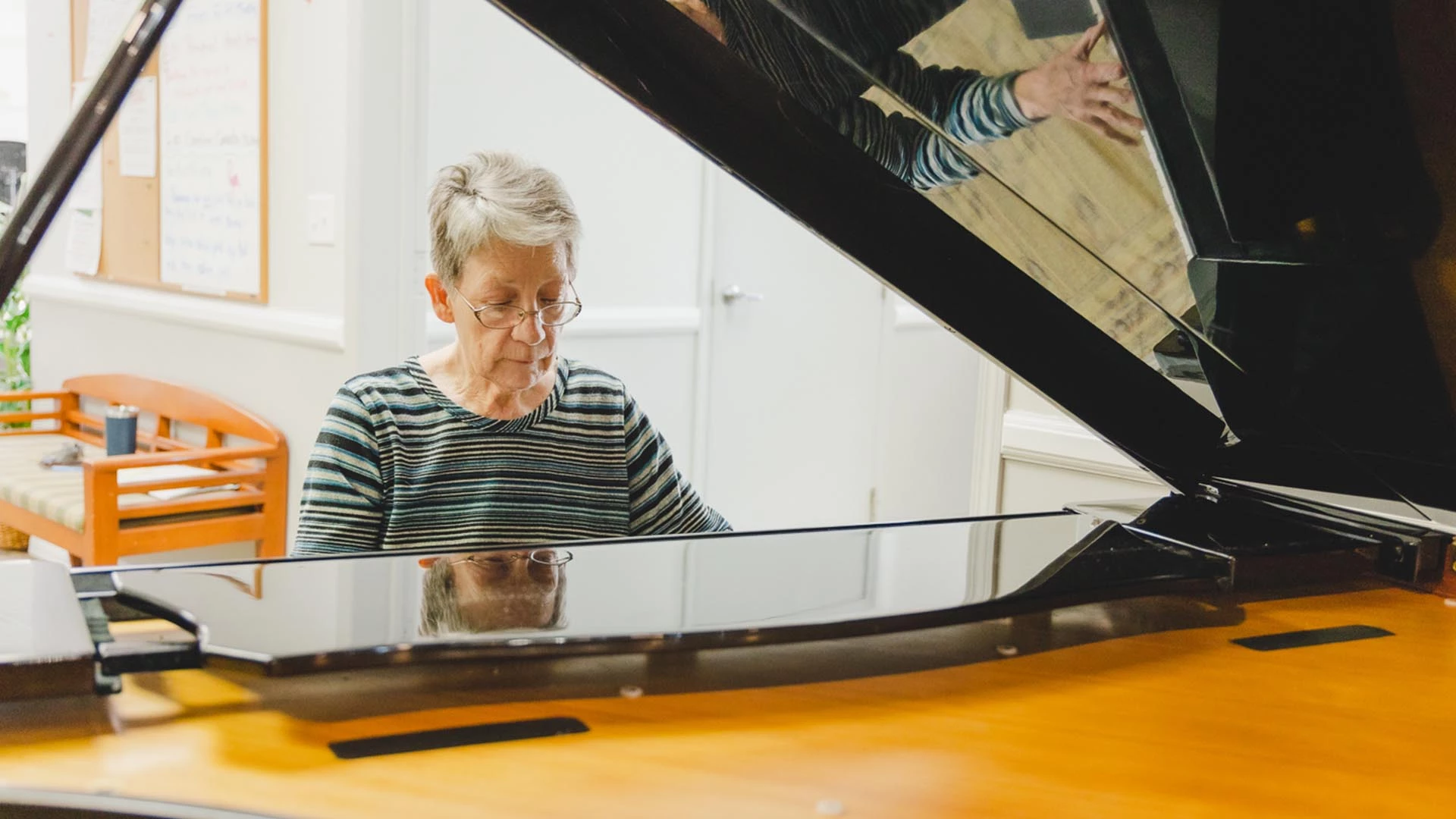 A senior woman playing a piano